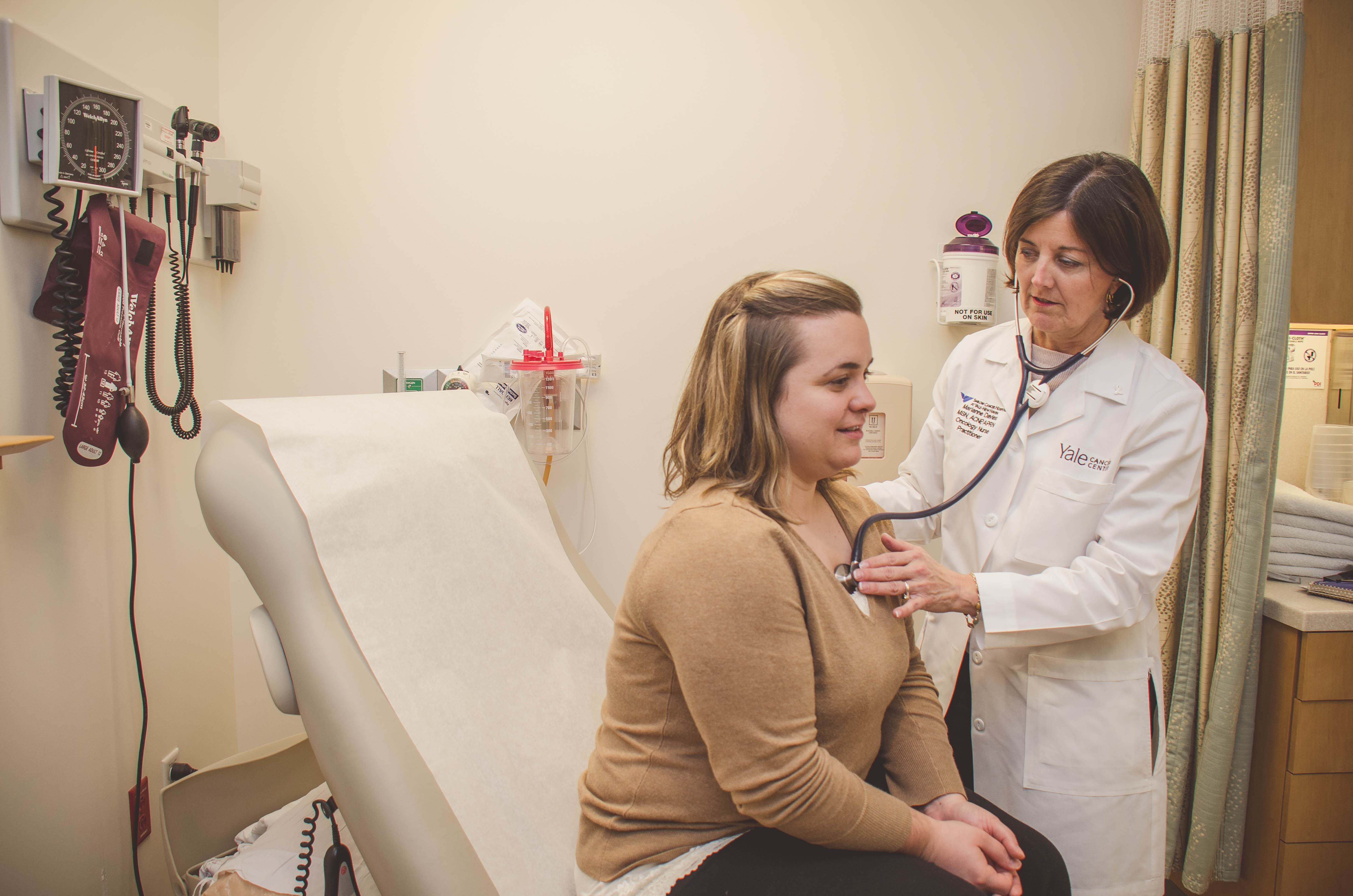 Faculty member Marianne Davies examines a patient at Smilow Cancer Hospital.