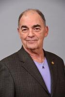 Headshot of Wailua Brandman wearing a dark blazer and purple shirt.