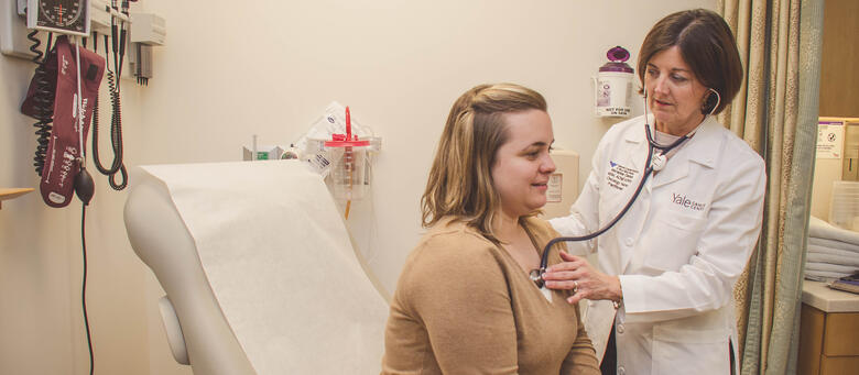 Faculty member Marianne Davies examines a patient at Smilow Cancer Hospital.