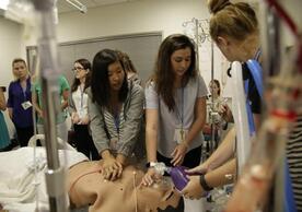 Students giving CPR to a simulation manikin.