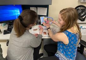 Anna Bristow ’21 MSN (left) discusses patient care with Ash Draper, ’16 MSN